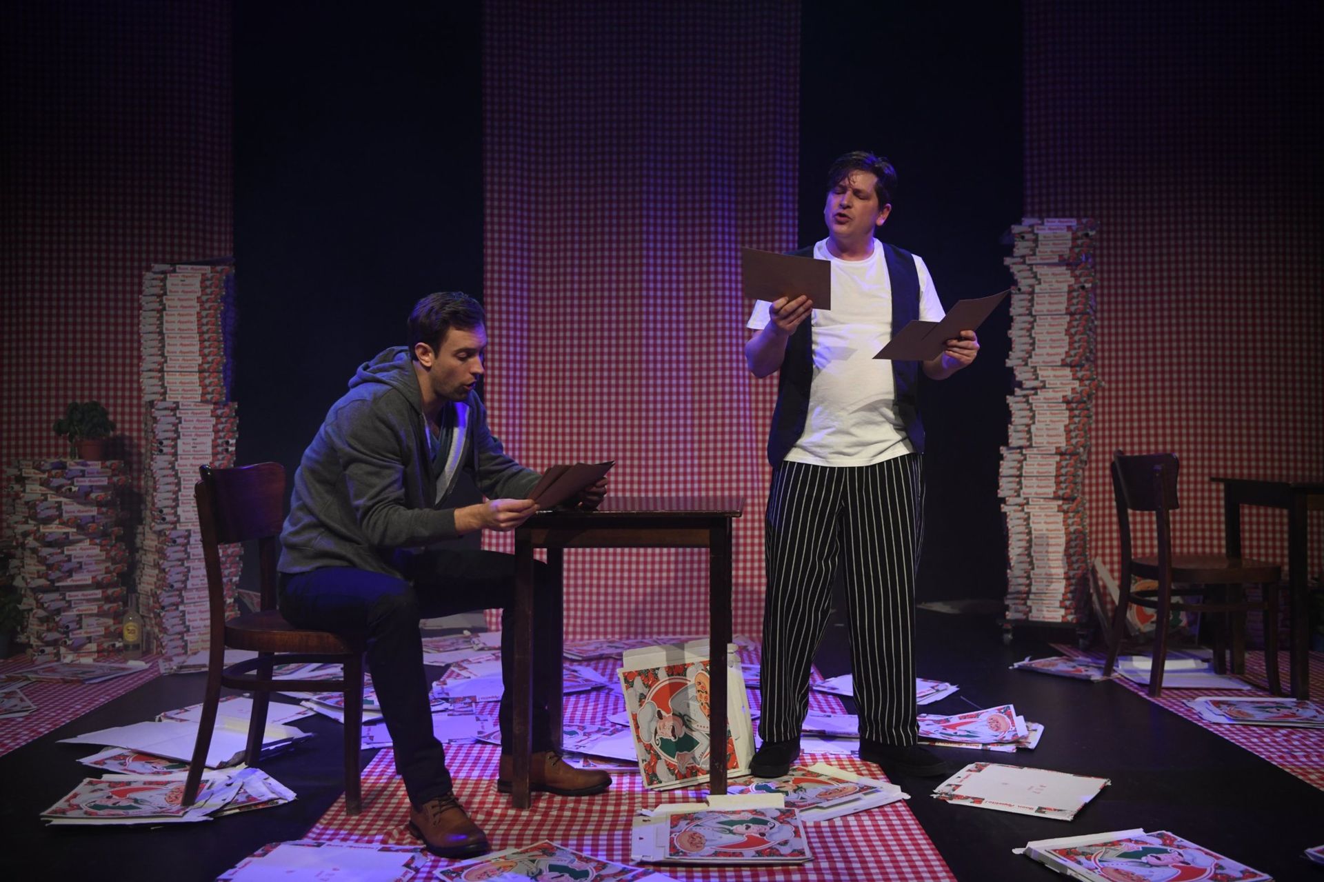 Romeo en de pizzabakker met de menukaarten in de pizzeria, scène uit Romeo & Julia 2018